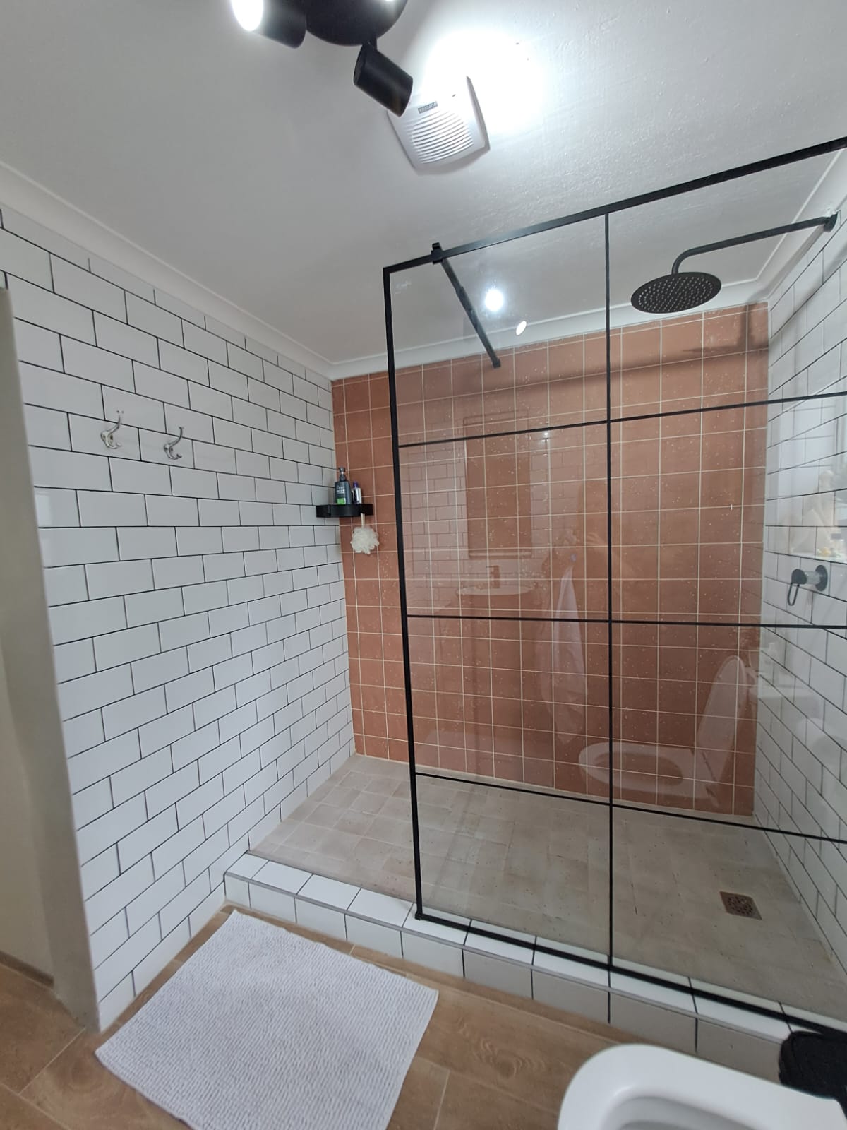 Walk-in rain shower with black fixtures